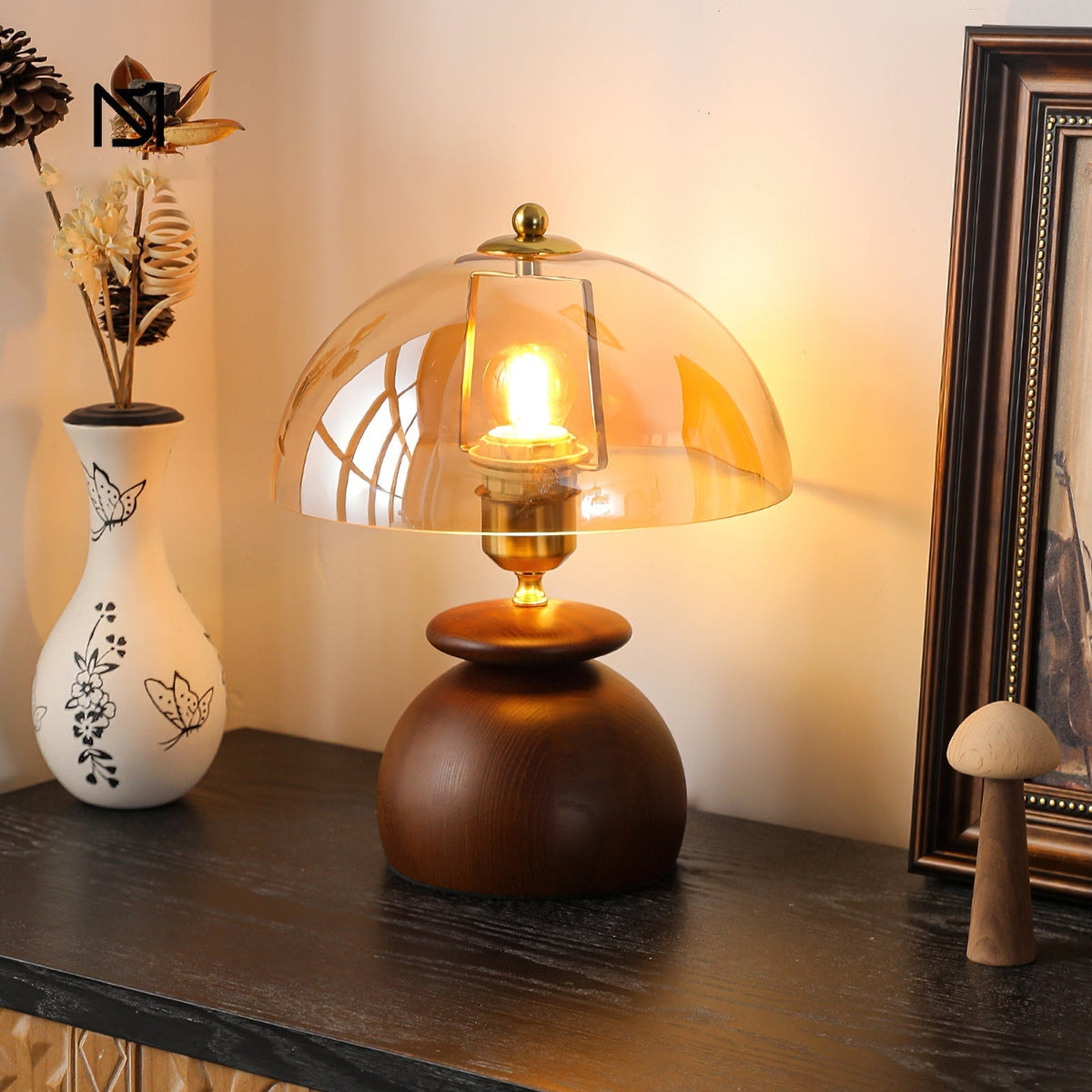 Close-up of the Valeska Table Lamp's amber glass shade and gold finial.