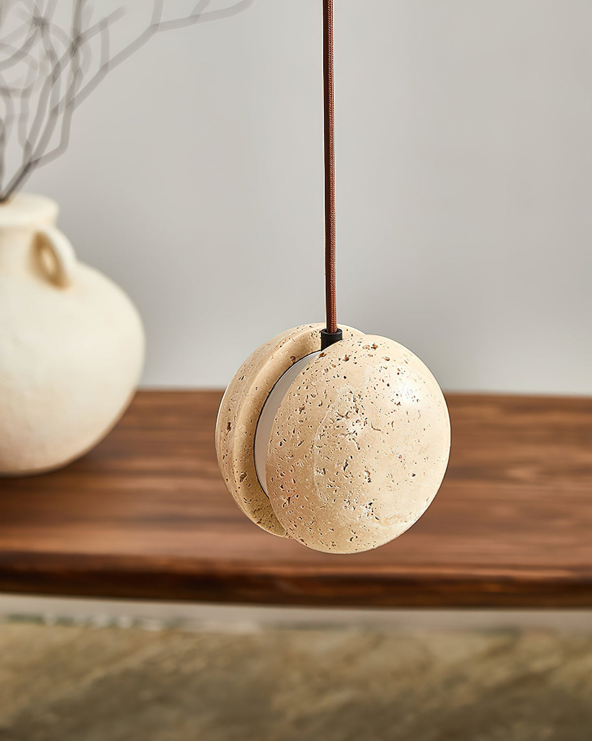 Detail shot of the split-sphere design of the travertine pendant.