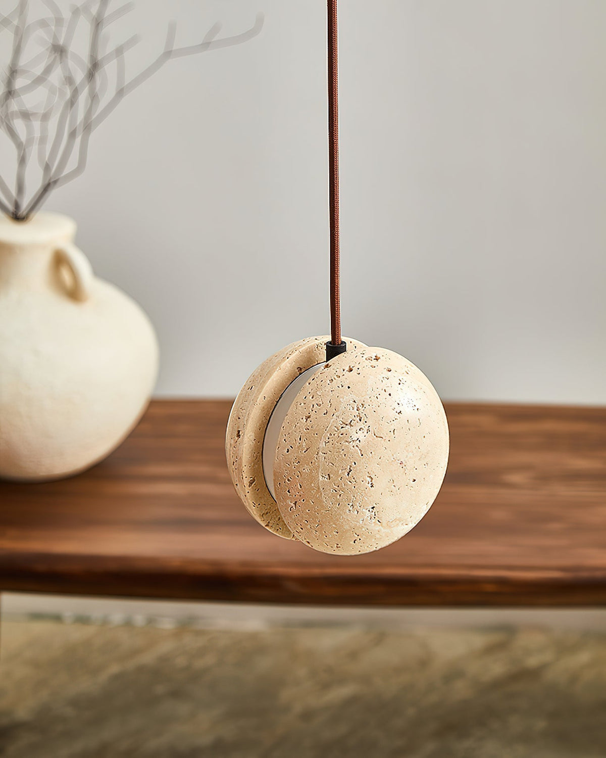 Unlit view of the pendant lamp, showcasing the beige and yellow tones of the travertine.