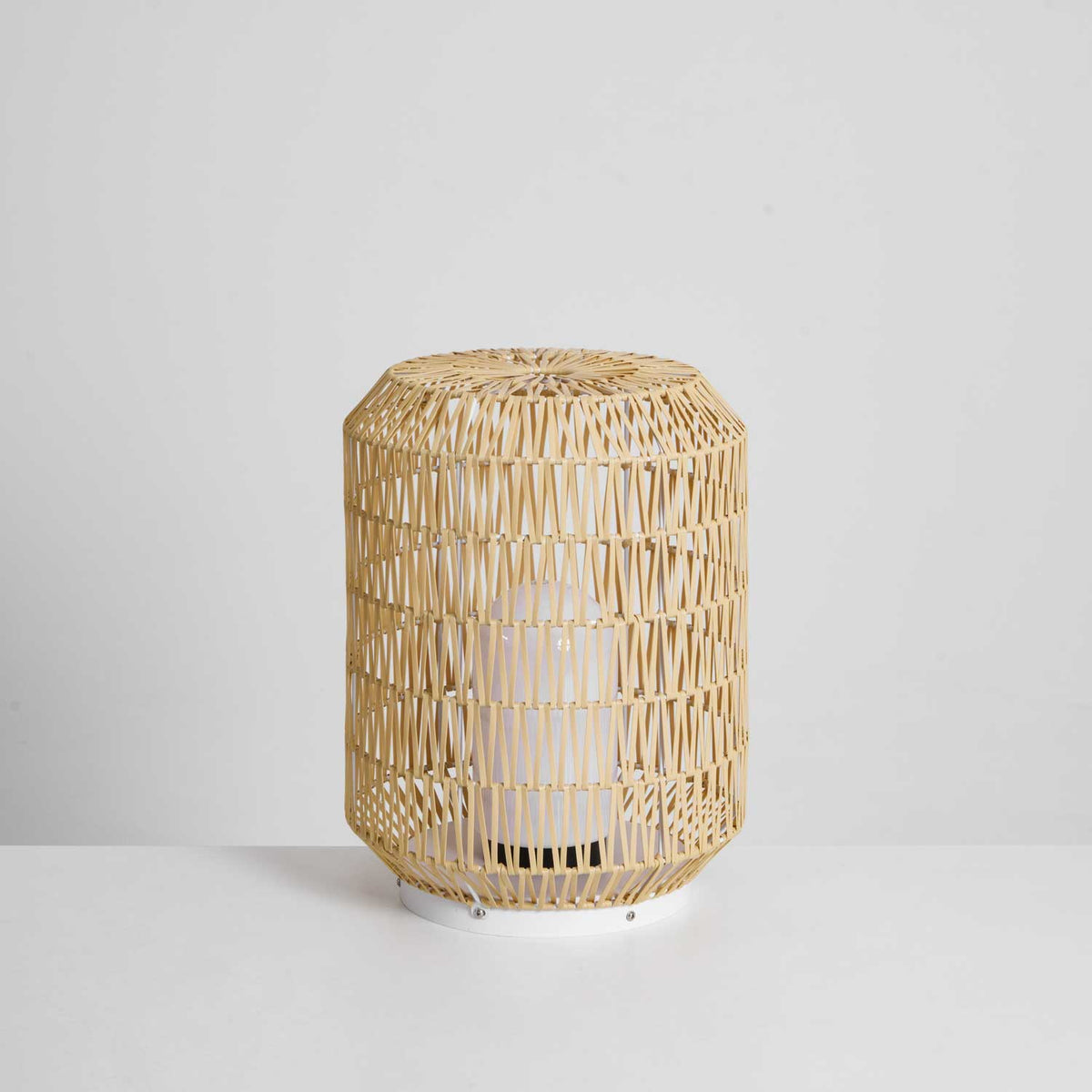 The woven rattan outdoor lamp in a garden environment.