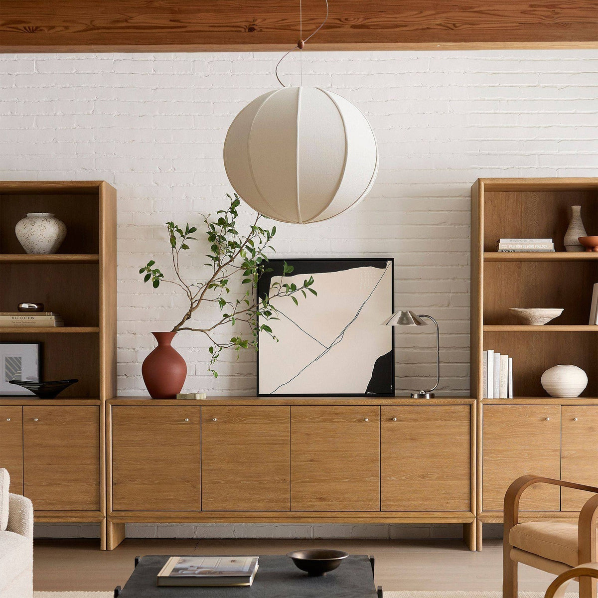 The spherical Yaratam Pendant Light illuminated over a dining area.