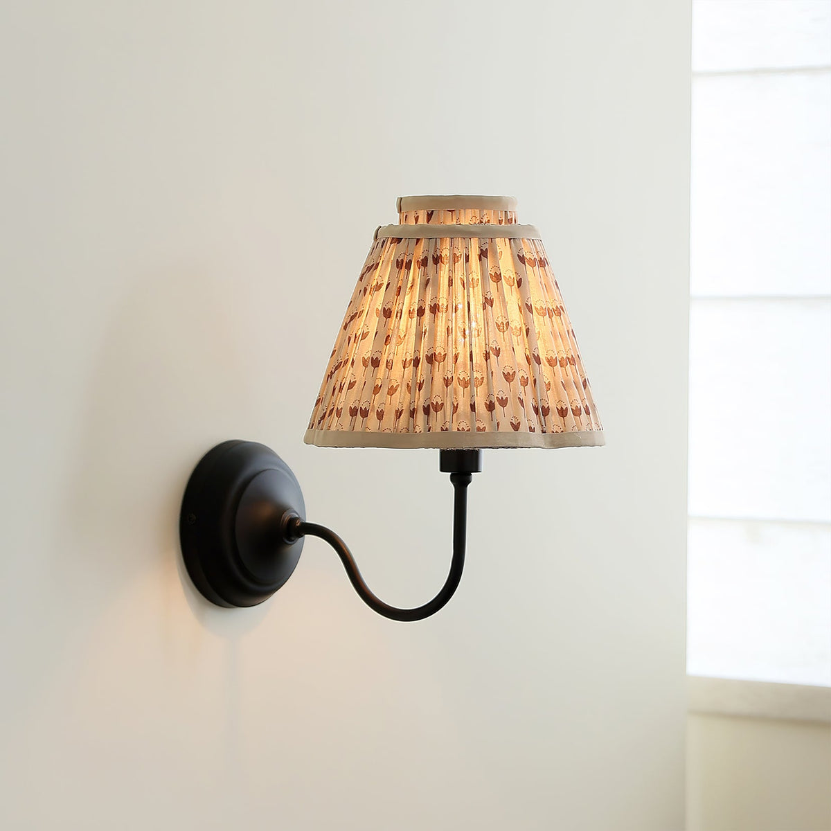Close-up of the pleated fabric shade showing the delicate floral pattern.