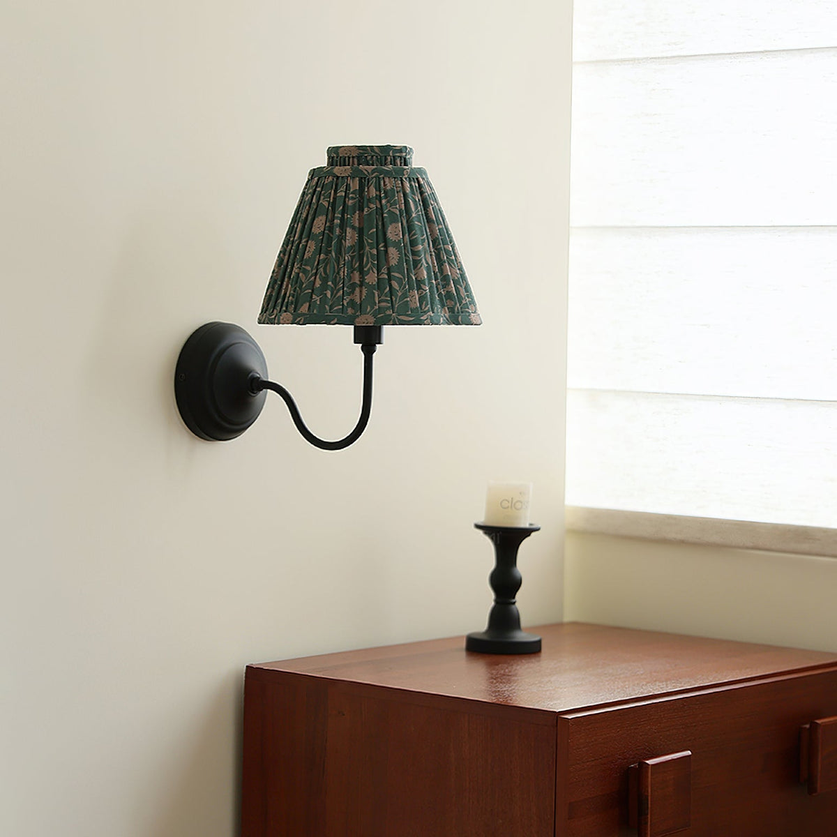 Detail of the black curved metal arm and wall mounting plate.
