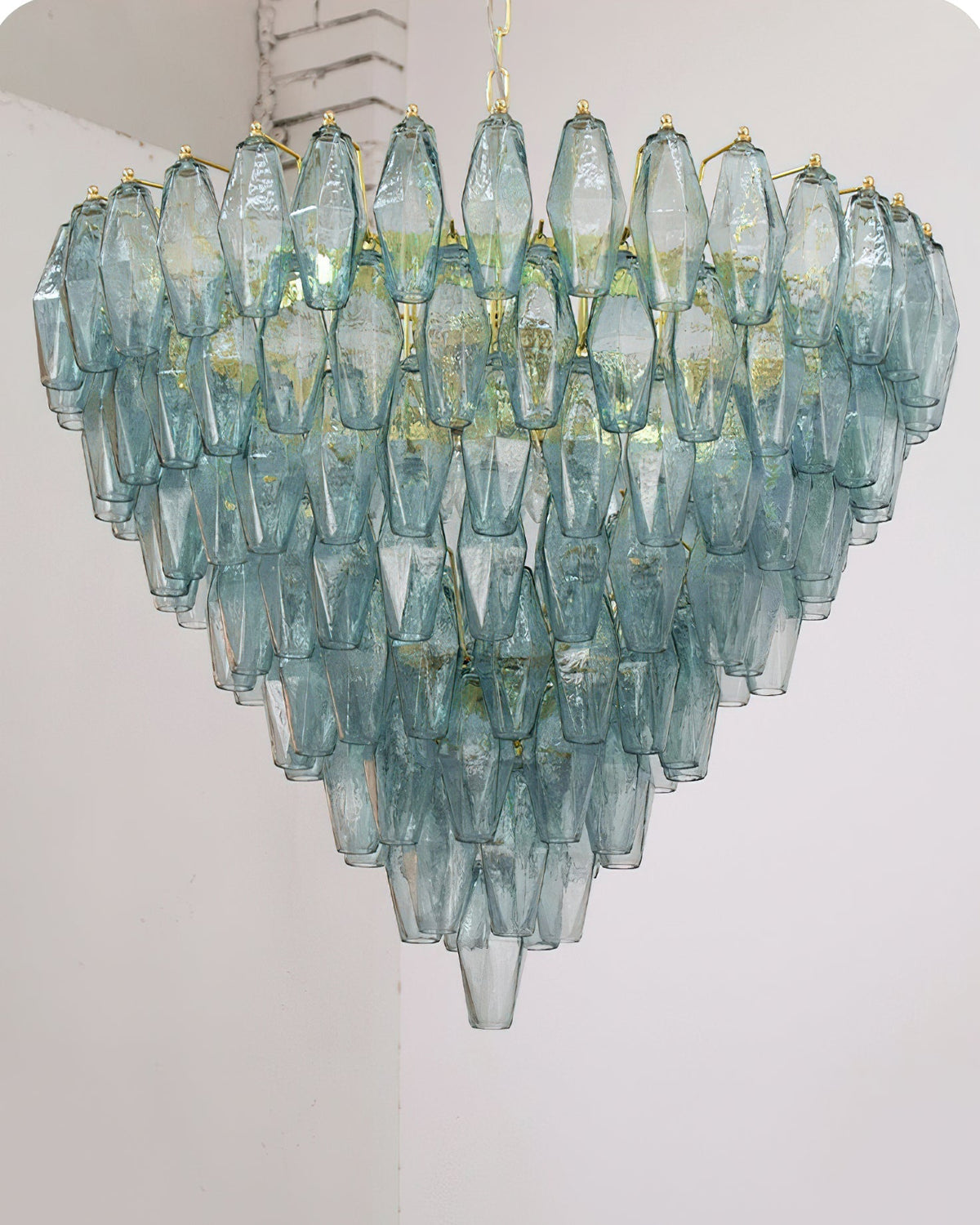 Ametista Chandelier with purple glass prisms against a dark, dramatic wall.