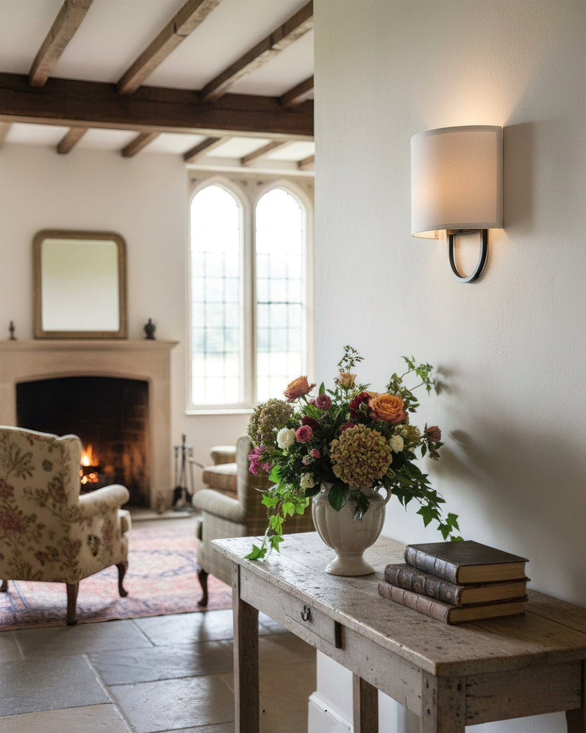 Close-up of the brass arm and fabric shade on the Atticus Wall Lamp.