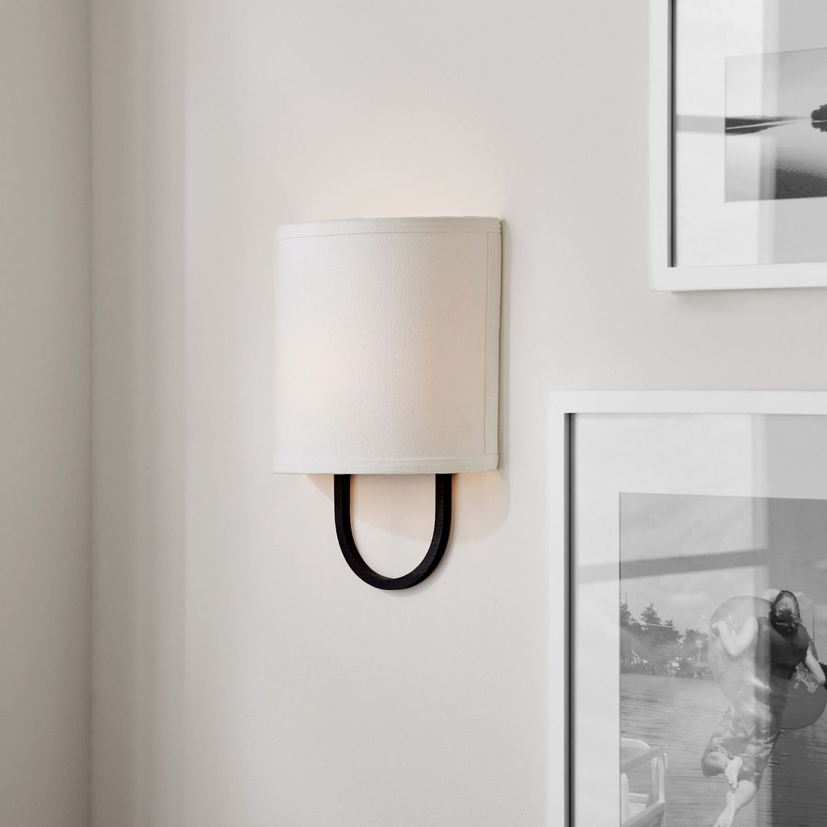 The Atticus Wall Lamp illuminating a modern hallway.