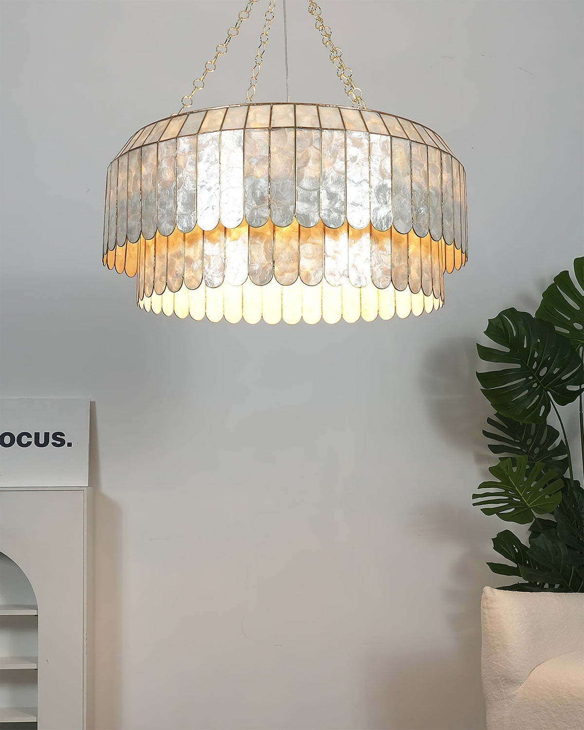 View of the lamp's gold ceiling mount and hanging chain.