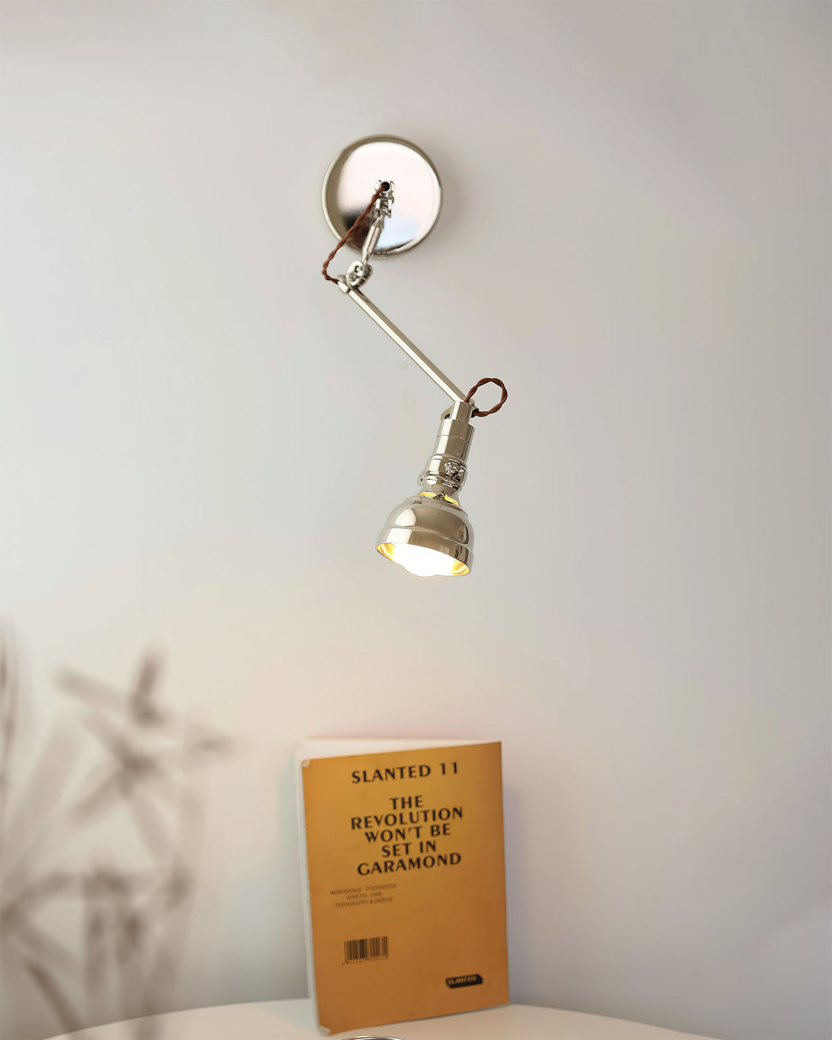 The wall lamp extended over a bedside table.