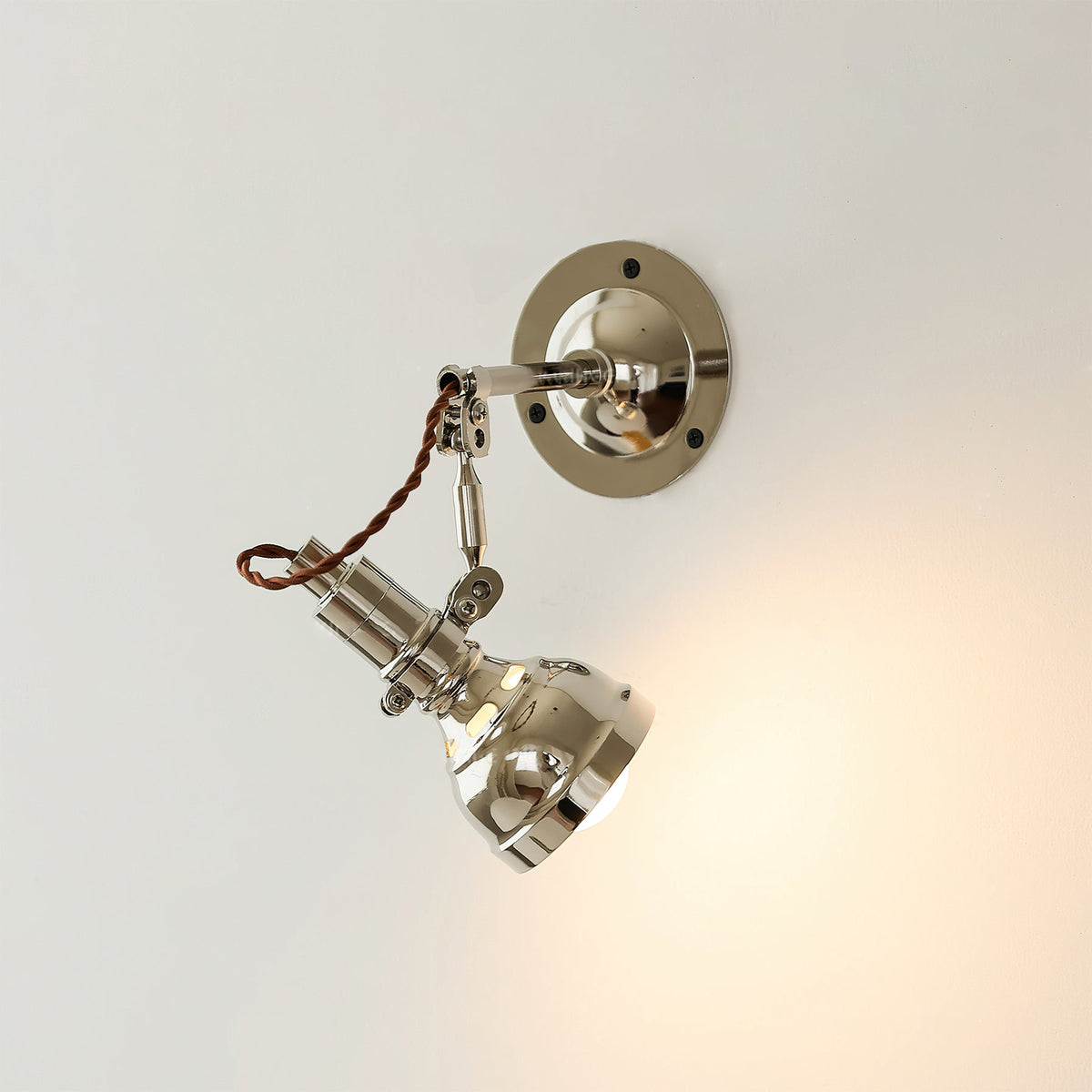 Angled view showing the adjustable arm of the wall lamp.