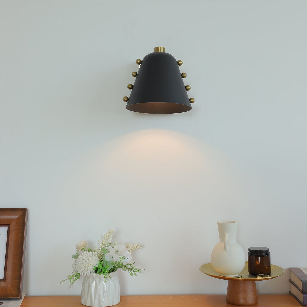 Bespoke geometric wall lamp in gold finish against a dark wall.