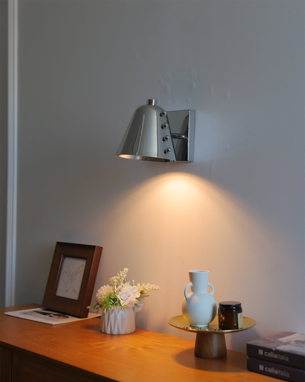 Bespoke wall lamp illuminating a piece of art.