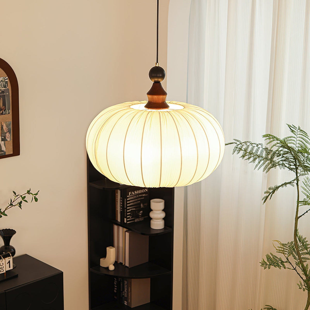 The Bowie Pendant Light hanging over a dining table, casting a warm glow.