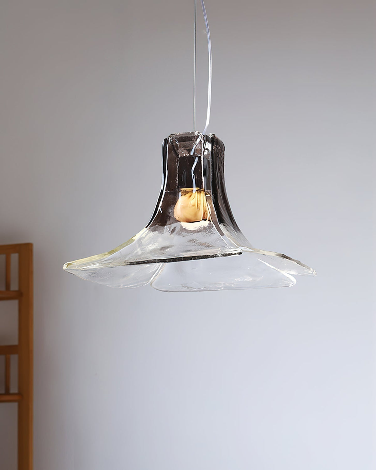 The smoky gray Carlo Pendant Light lit up in a contemporary living space.