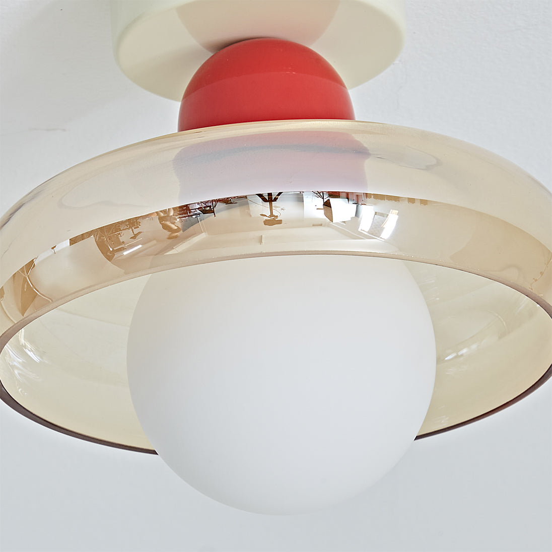 The Alabax Ceiling Light in cognac, casting a warm glow in a living room setting.