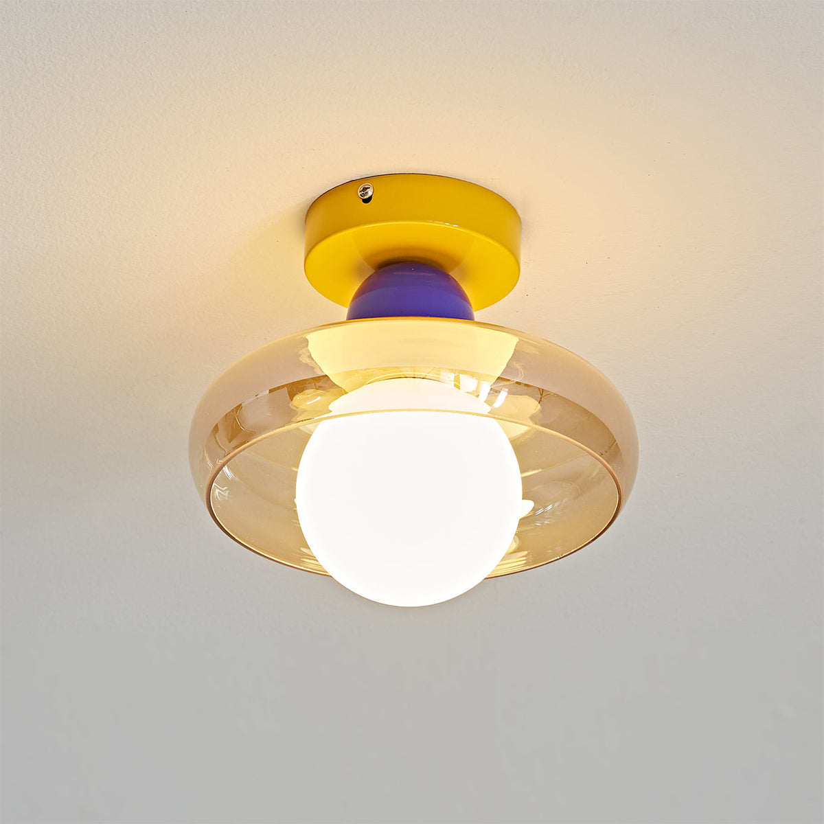 The Alabax Ceiling Light in yellow, adding a pop of color to a hallway.