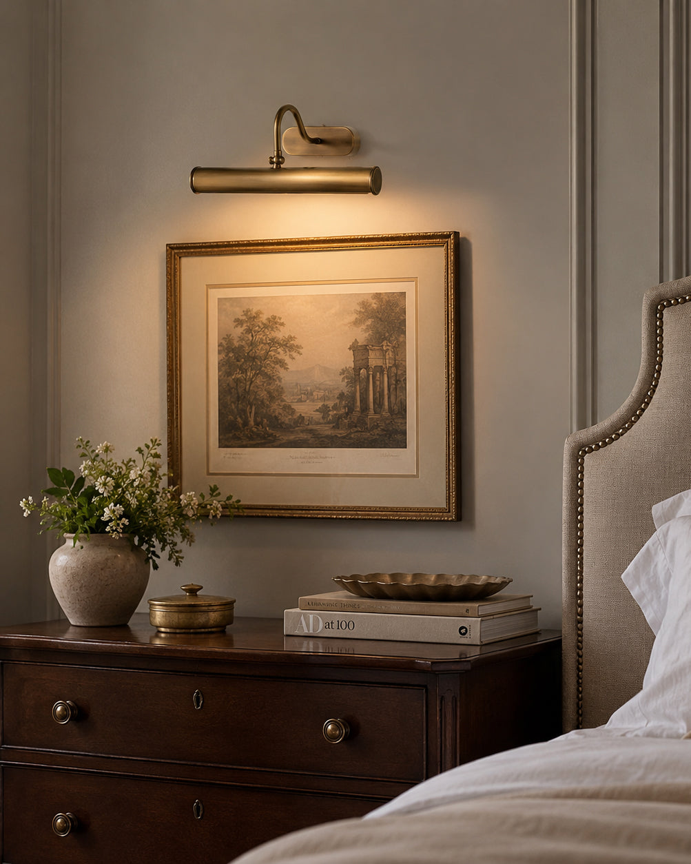 Angled view of the Ainsworth Brass Wall Sconce against a light-colored wall.