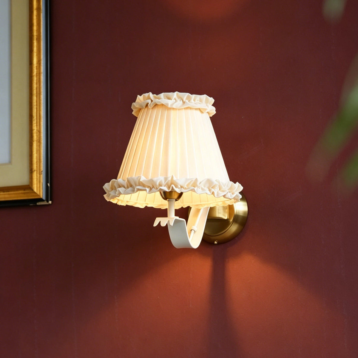 Close-up of the pleated beige fabric shade on the Chantal wall sconce.