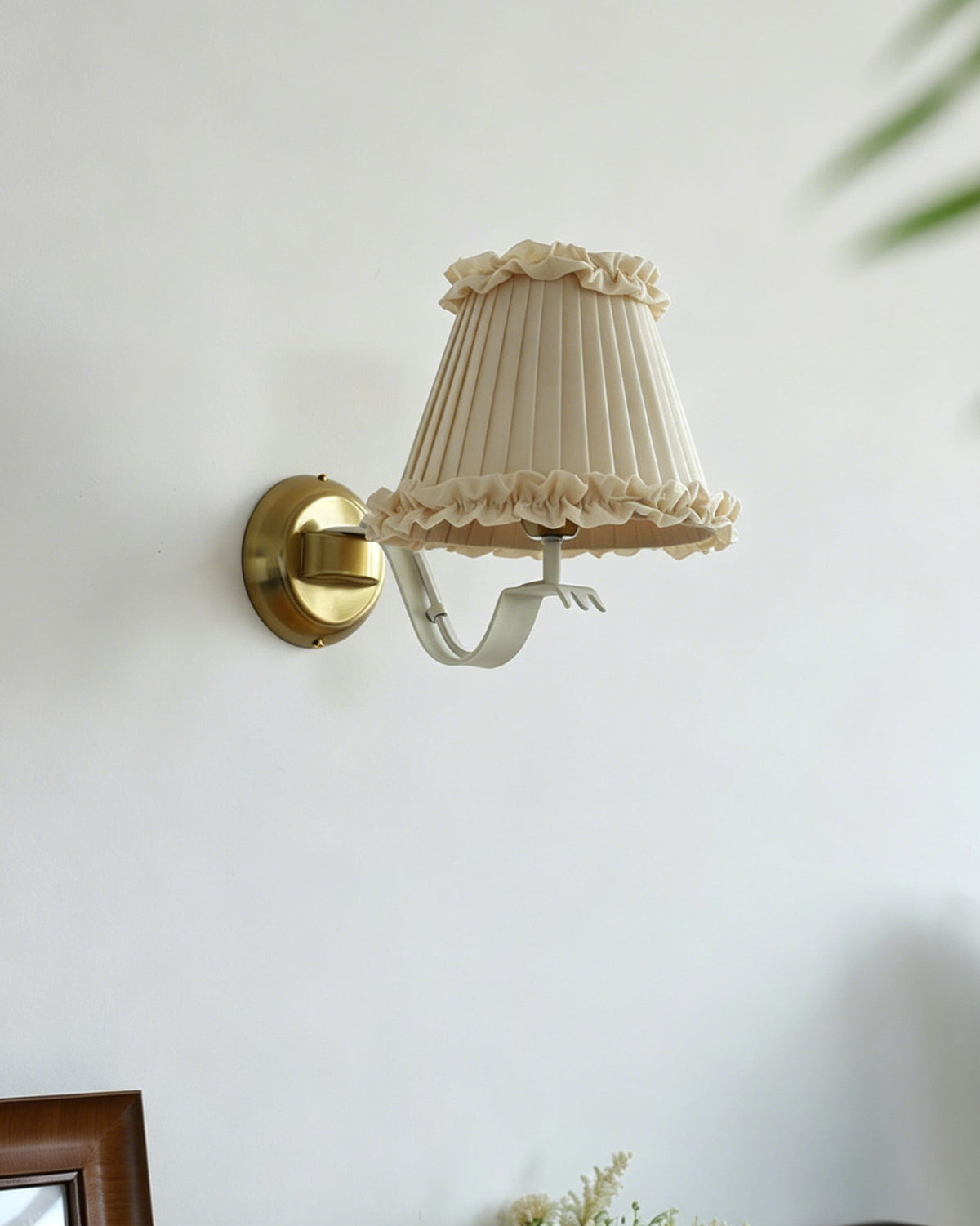 Chantal Ruffle Wall Sconce installed in a hallway with wainscoting.
