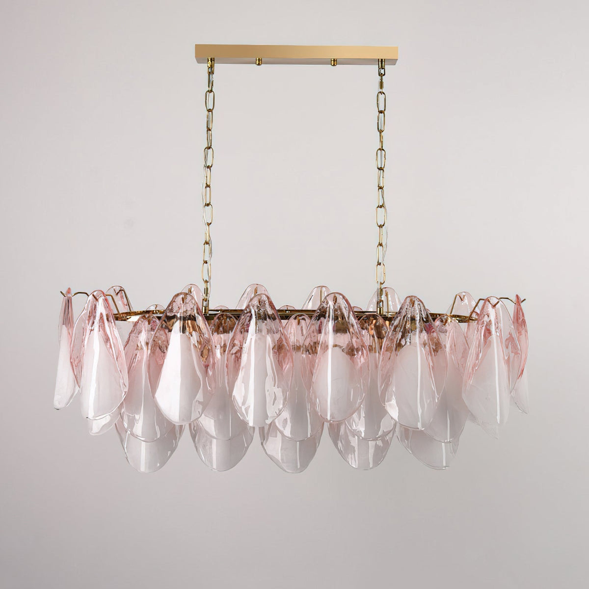 Close-up of the Flora chandelier's overlapping blush ombre glass leaves and gold metal frame.