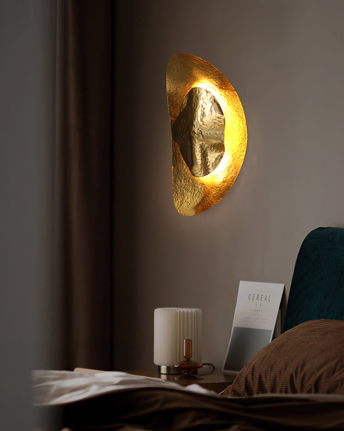 The natural brass finish of the Helios sconce catching the light.