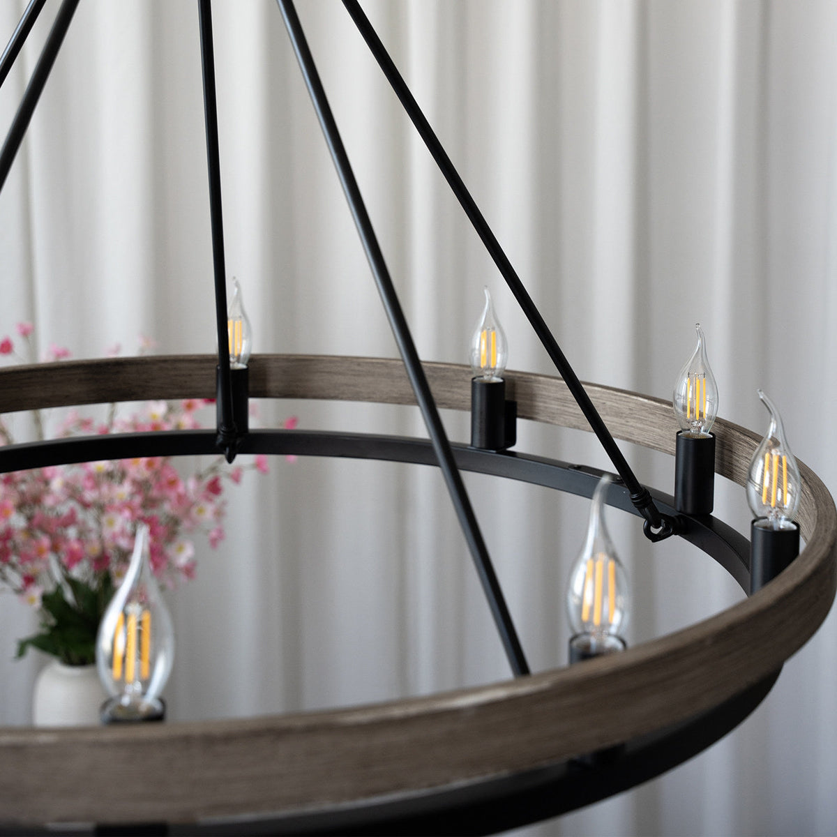 Detail view of the black metal and walnut finish of the chandelier.