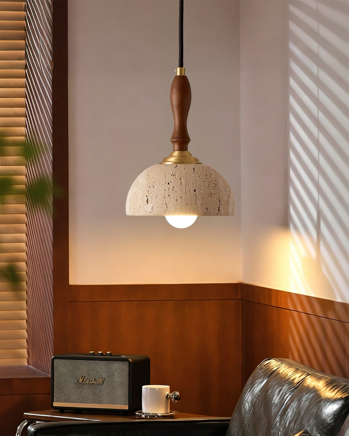 Close-up of the Enora pendant light showing the travertine shade and wooden stem.