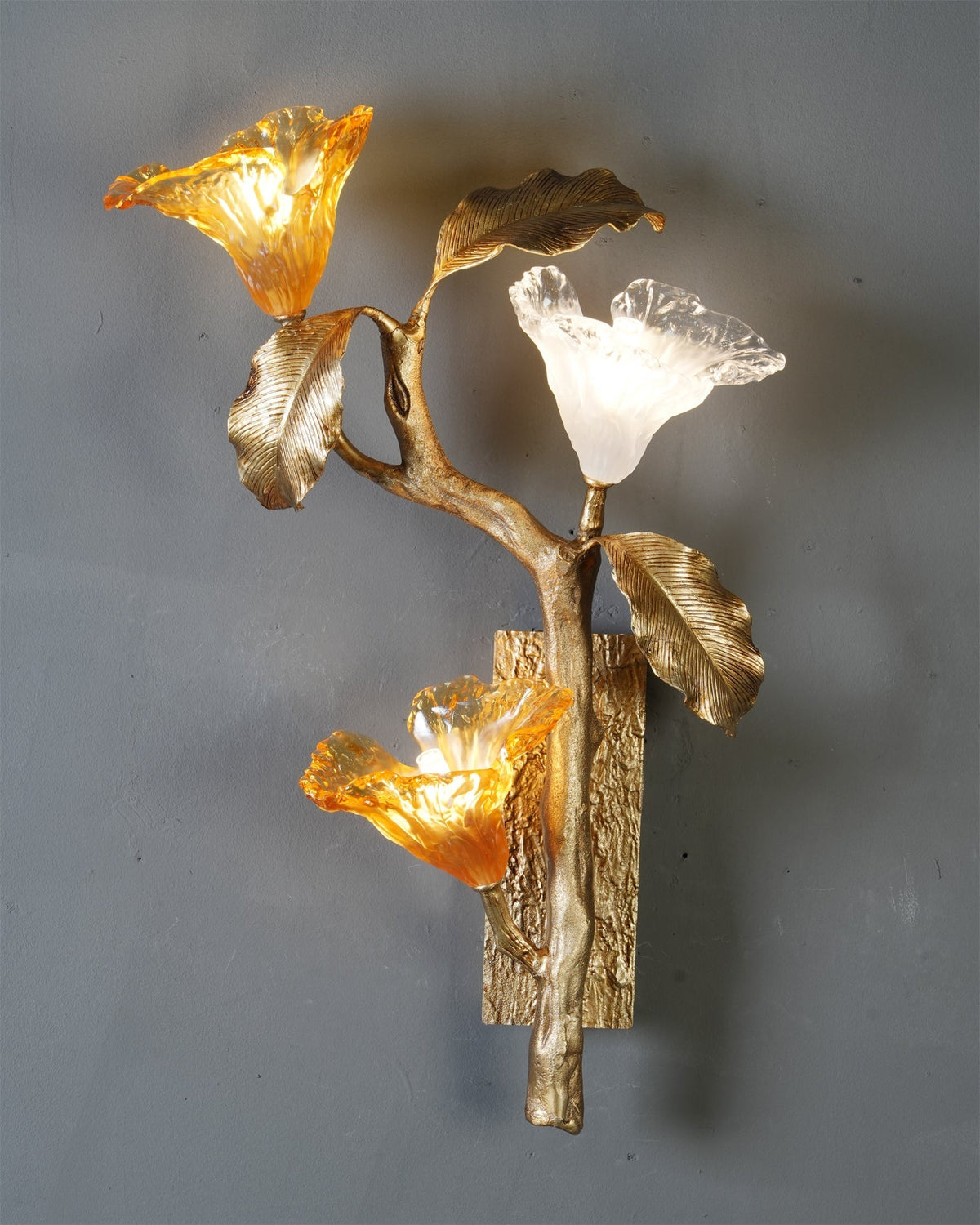 The sconce against a dark wall, highlighting the brass and glass.