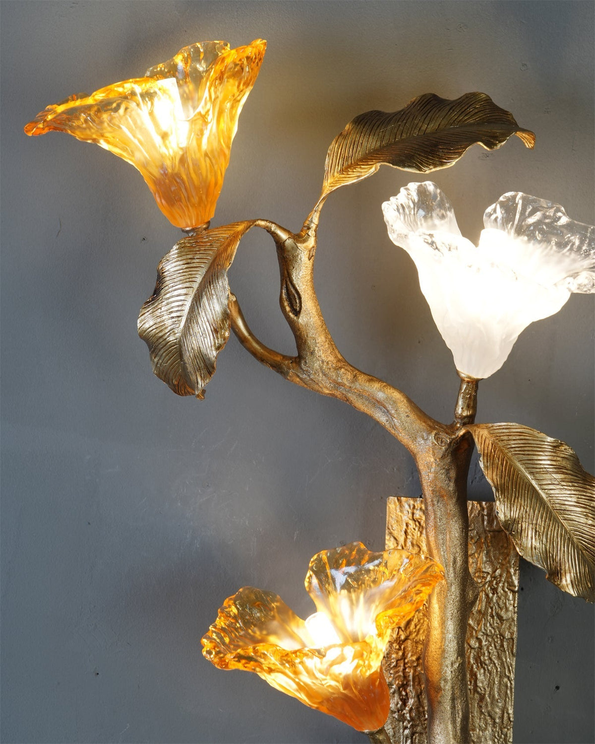 The three glass lily blooms shown together, two amber and one frosted.