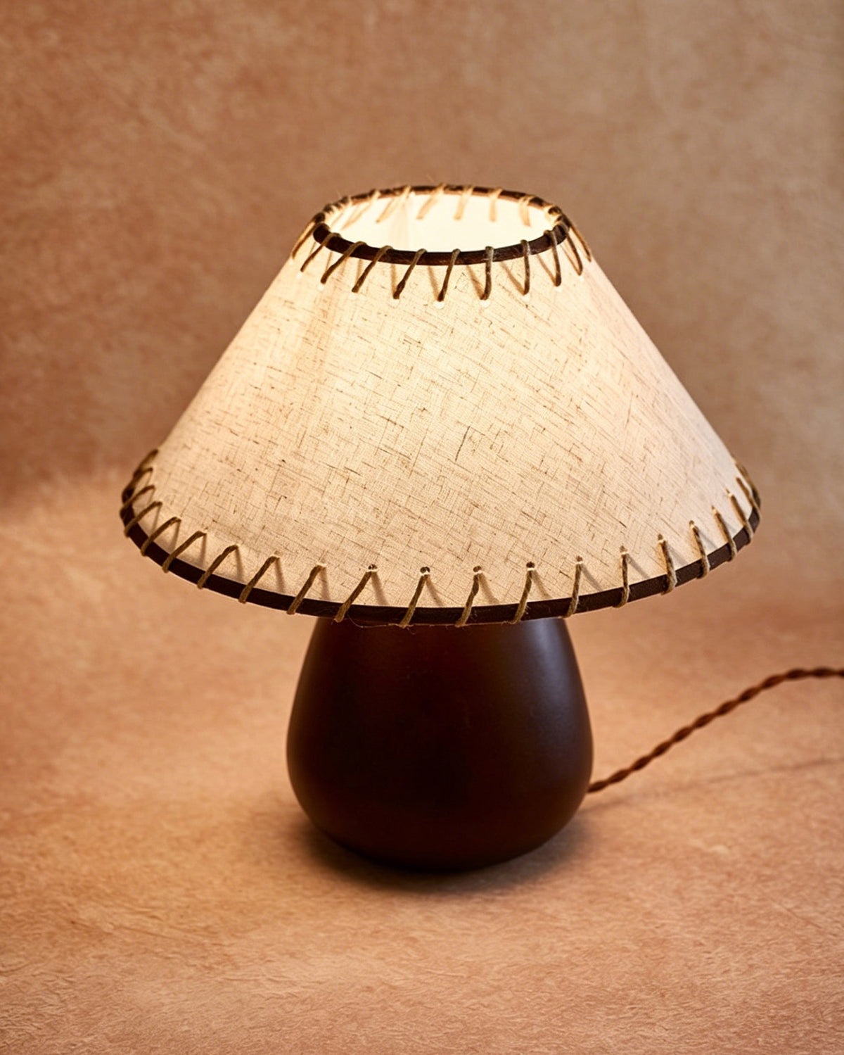The lamp illuminating a bedroom, casting a warm and inviting glow.