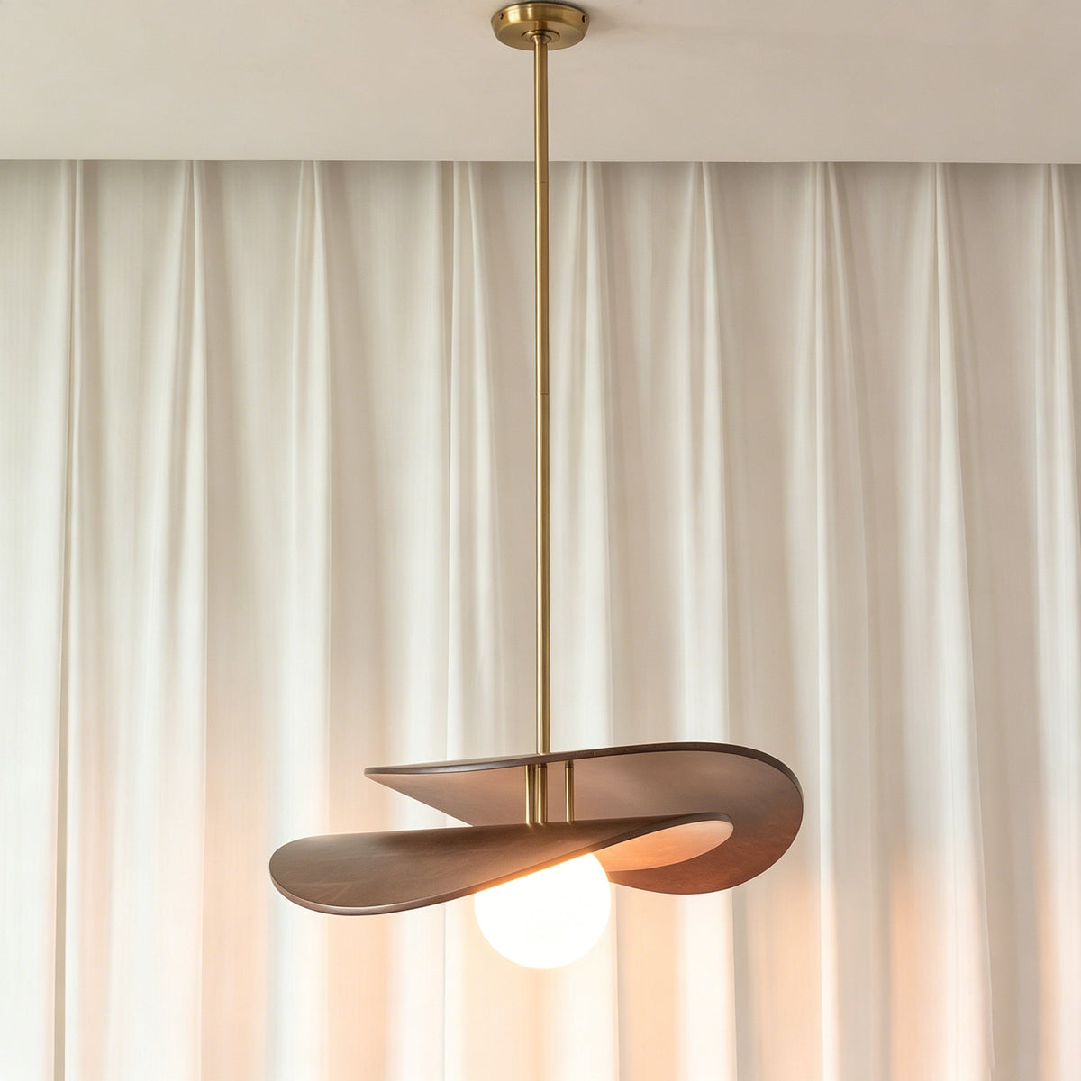The Zane walnut pendant light styled over a modern dining room table.