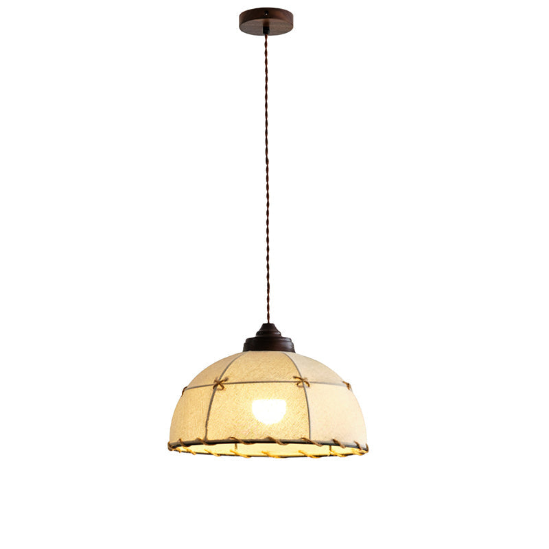 The Duomo Pendant Light adding a warm glow to a cozy bedroom setting.