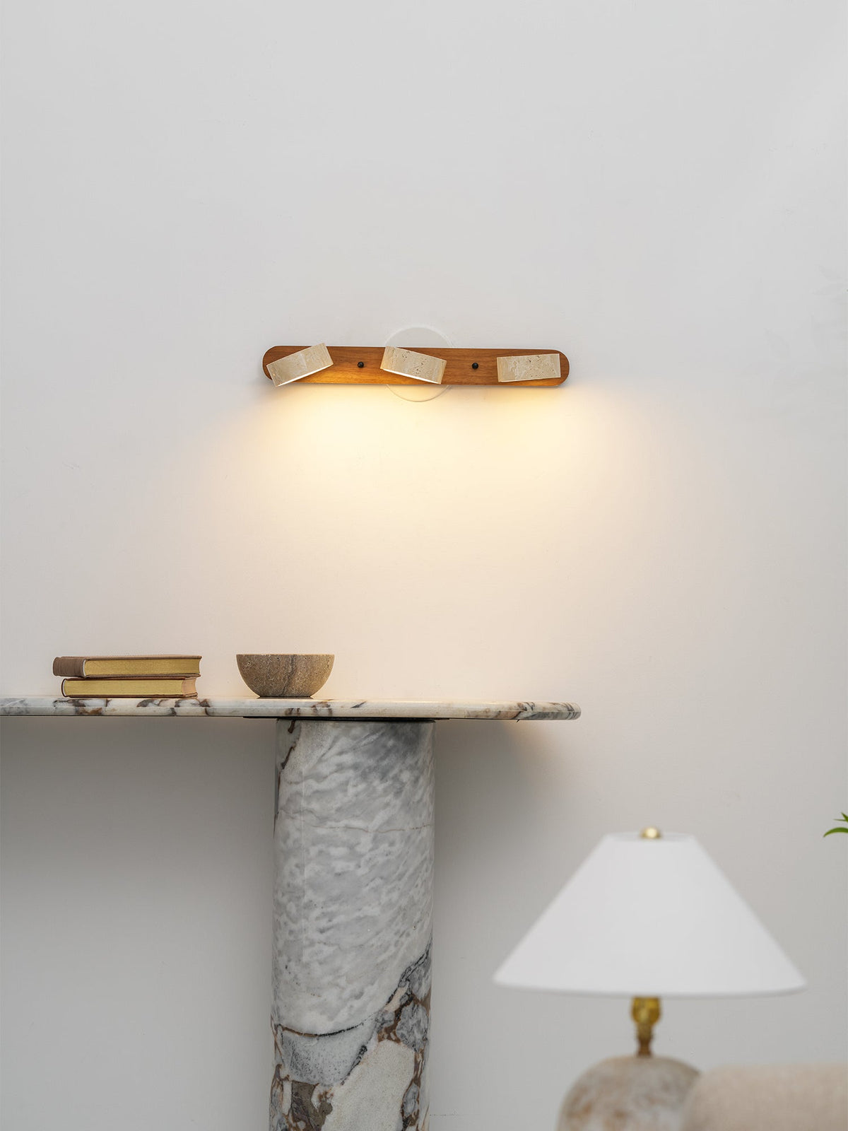 The 3-head lamp installed above a headboard in a bedroom.