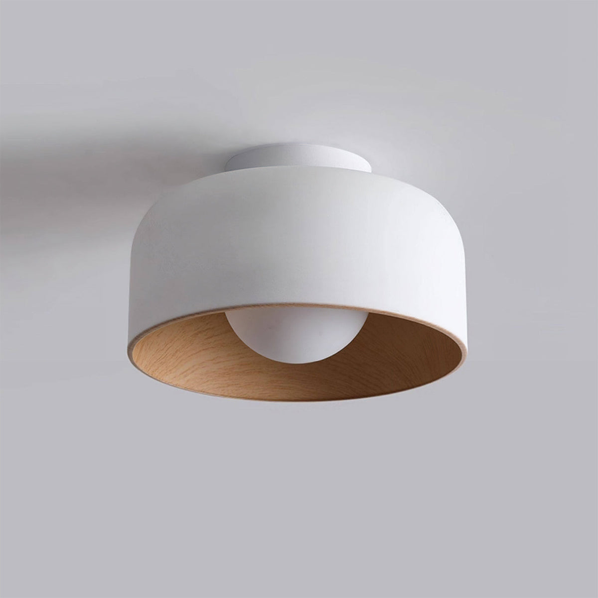 Close-up of the Folkio Ceiling Light's white glass shade and metal base.