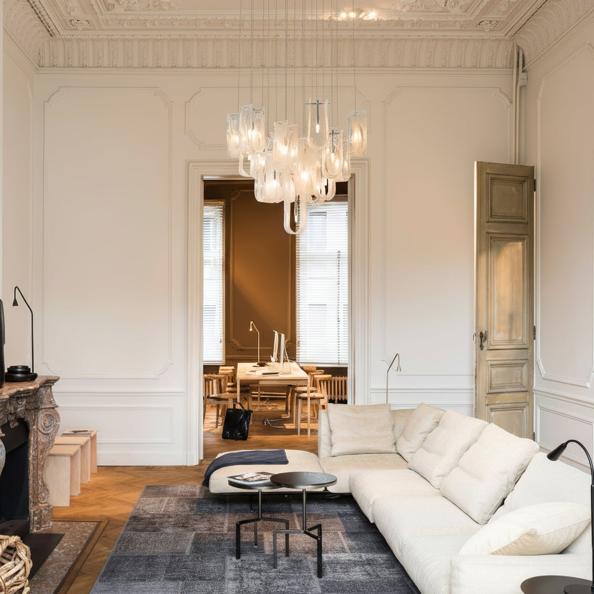 The Fontaine Chandelier installed in a modern living room, providing ambient light.