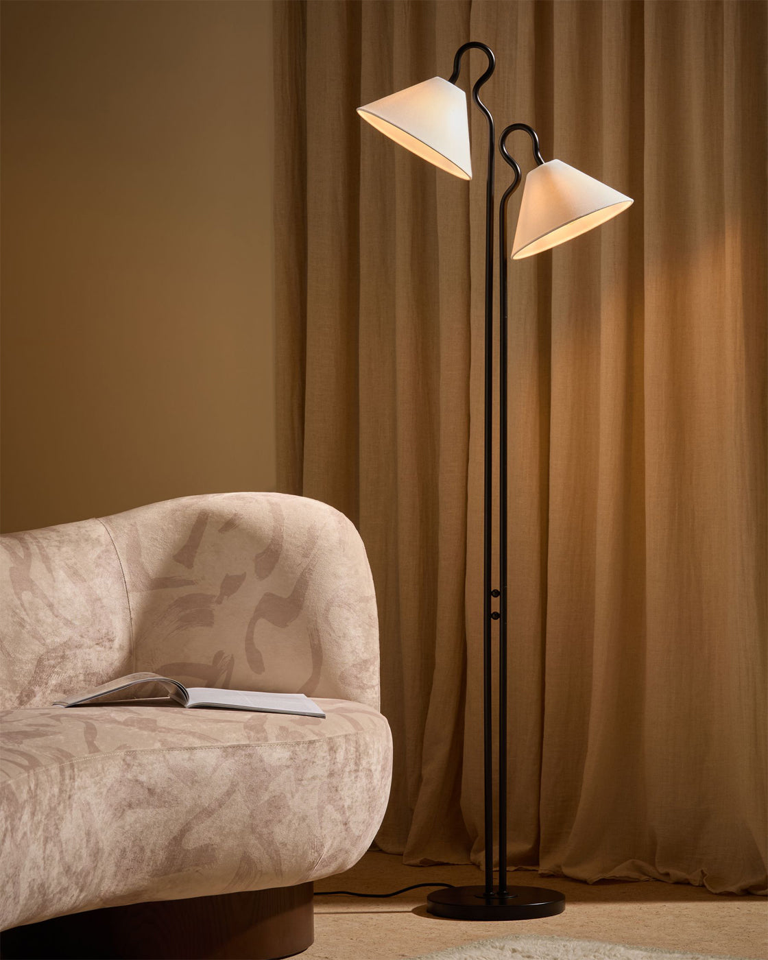 The Gerardo Floor Lamp providing light in a cozy reading corner.