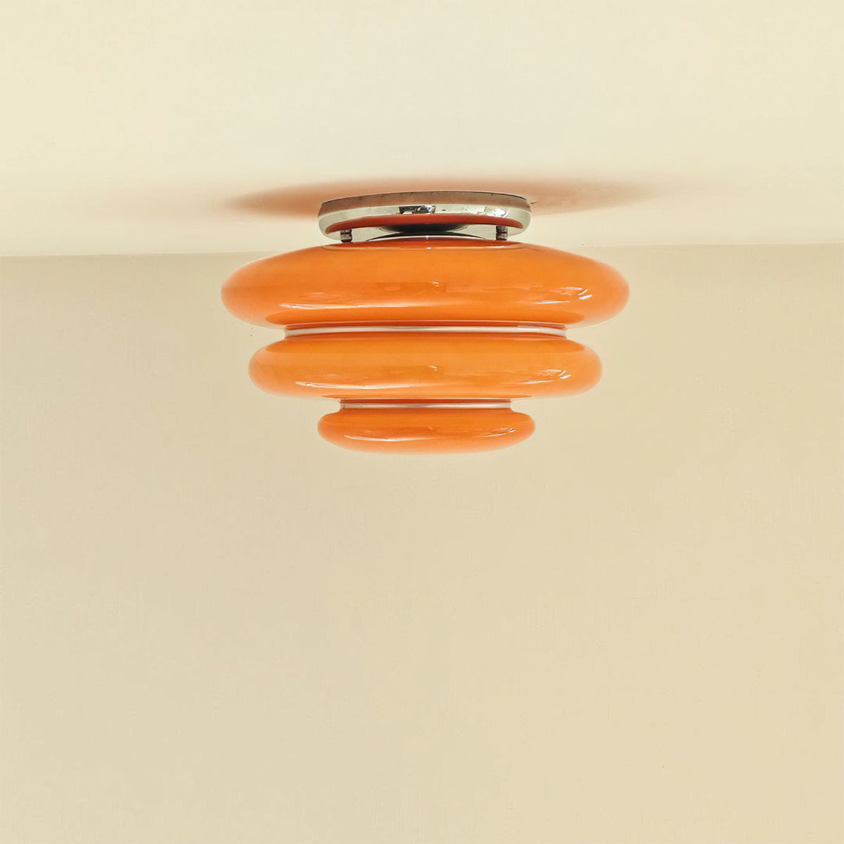 Close-up view of the vibrant orange glass layers on the Gispen ceiling light.