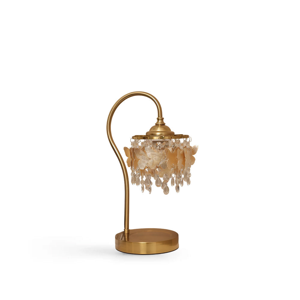 Jasinski Table Lamp with gold frame and shell butterfly details, shown on a table.