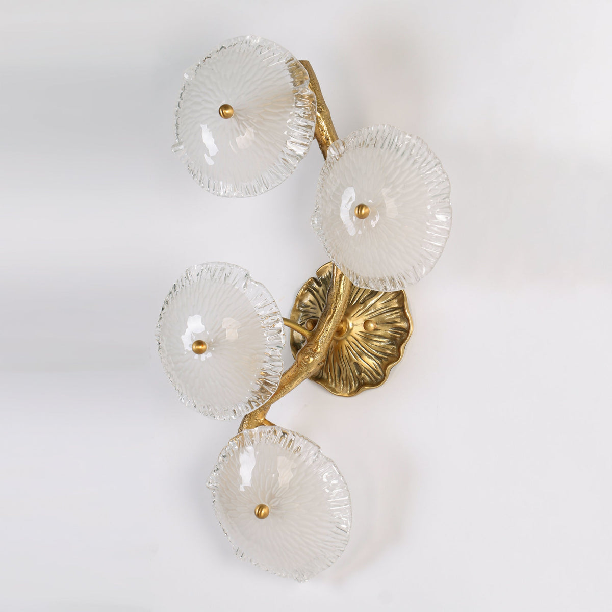 The Kamal Wall Lamp against a dark background to highlight the brass finish.