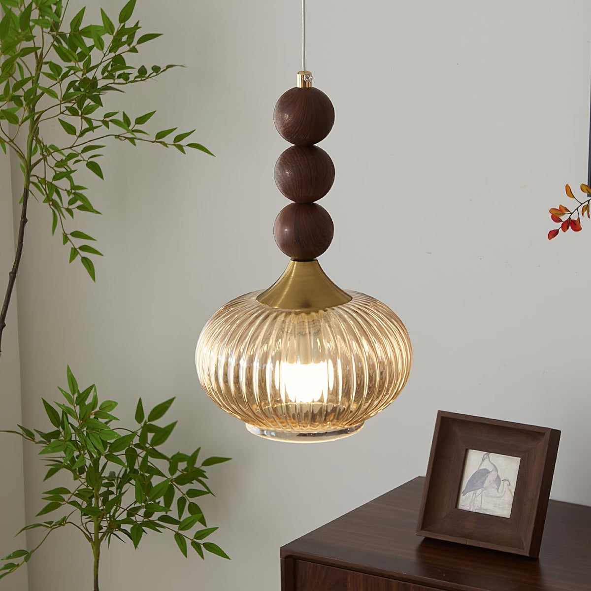 The Kaydan Pendant Lamp hanging in a modern living room, casting a warm light.