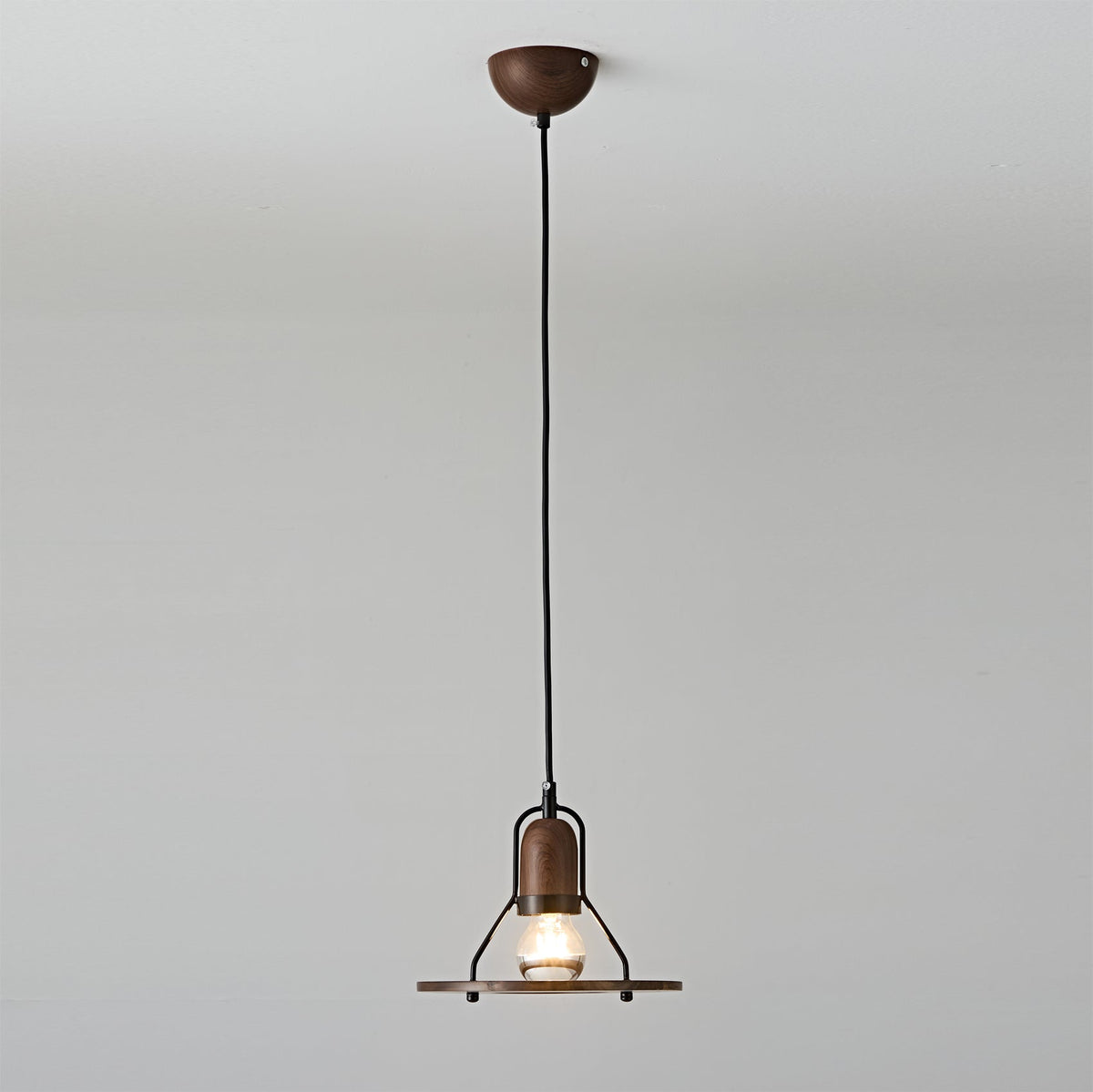 Close-up view of the Lioren Pendant Lamp's metal shade and walnut detail.