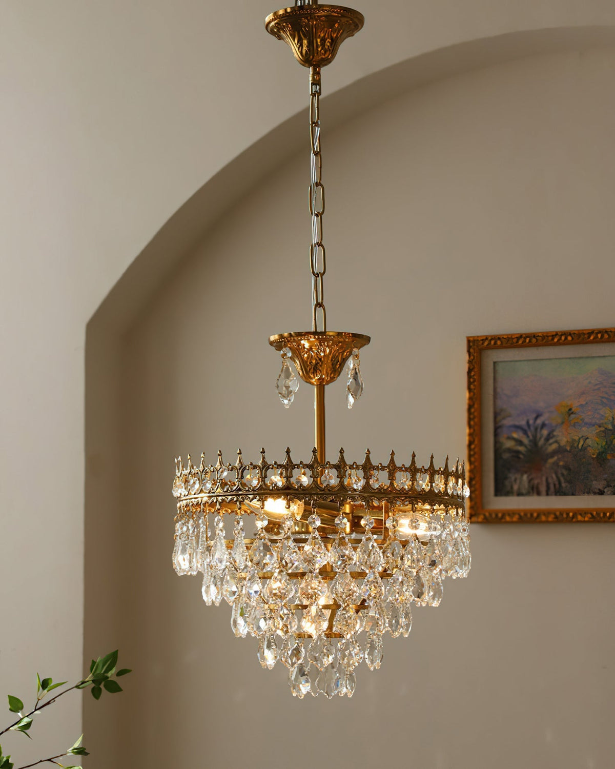Detail of the brushed gold metal finish on the chandelier's frame.