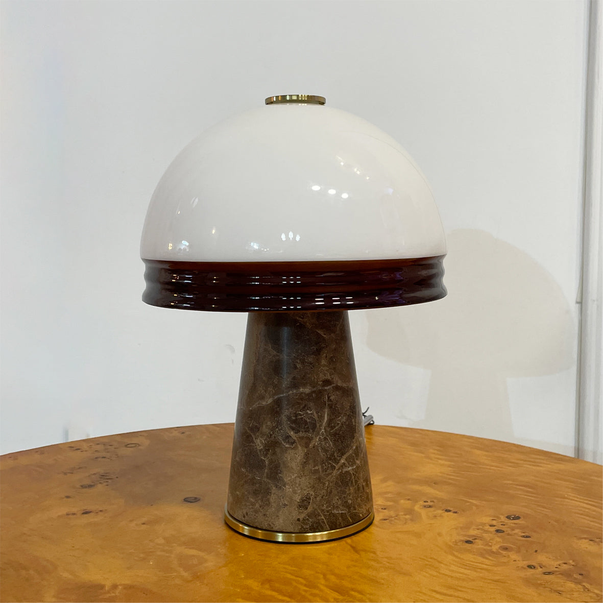 The Milano Table Lamp shown on a side table in a modern living room setting.