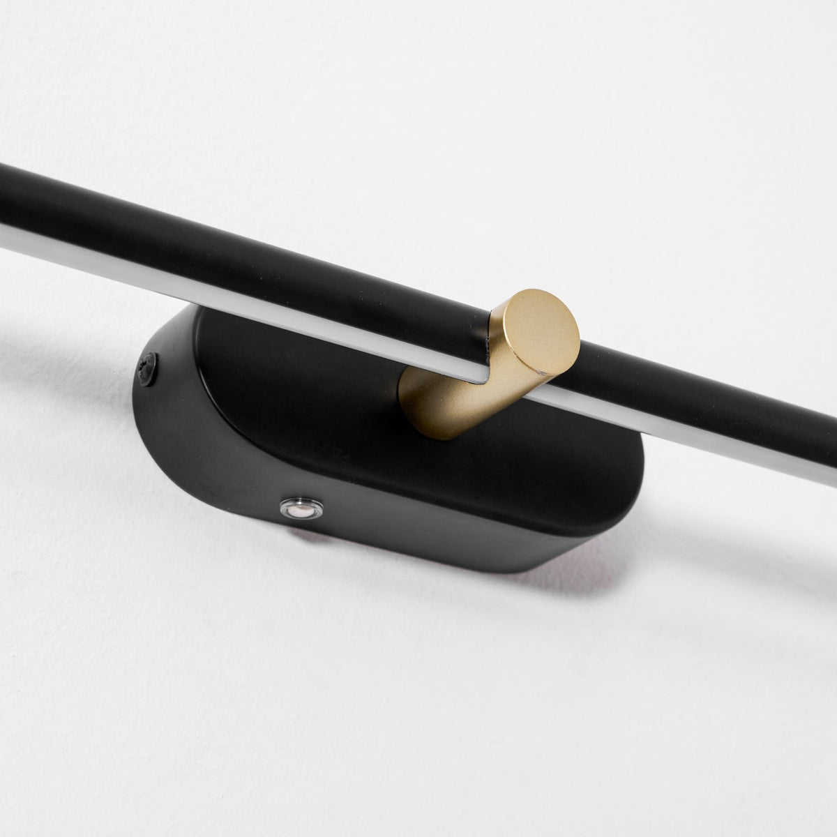 The rechargeable wall lamp in a minimalist bedroom setting.