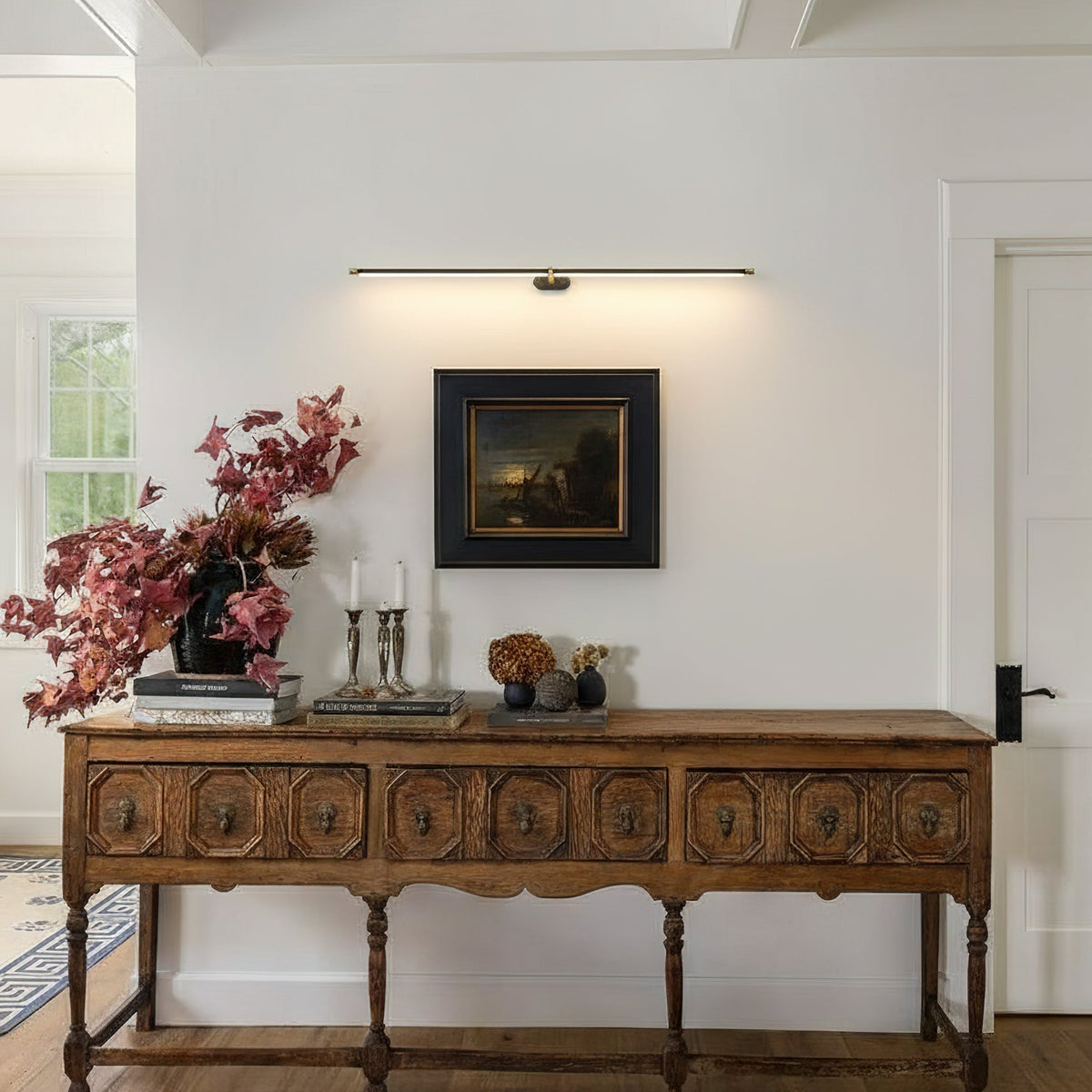 Brushed nickel linear wall lamp mounted in a modern hallway.