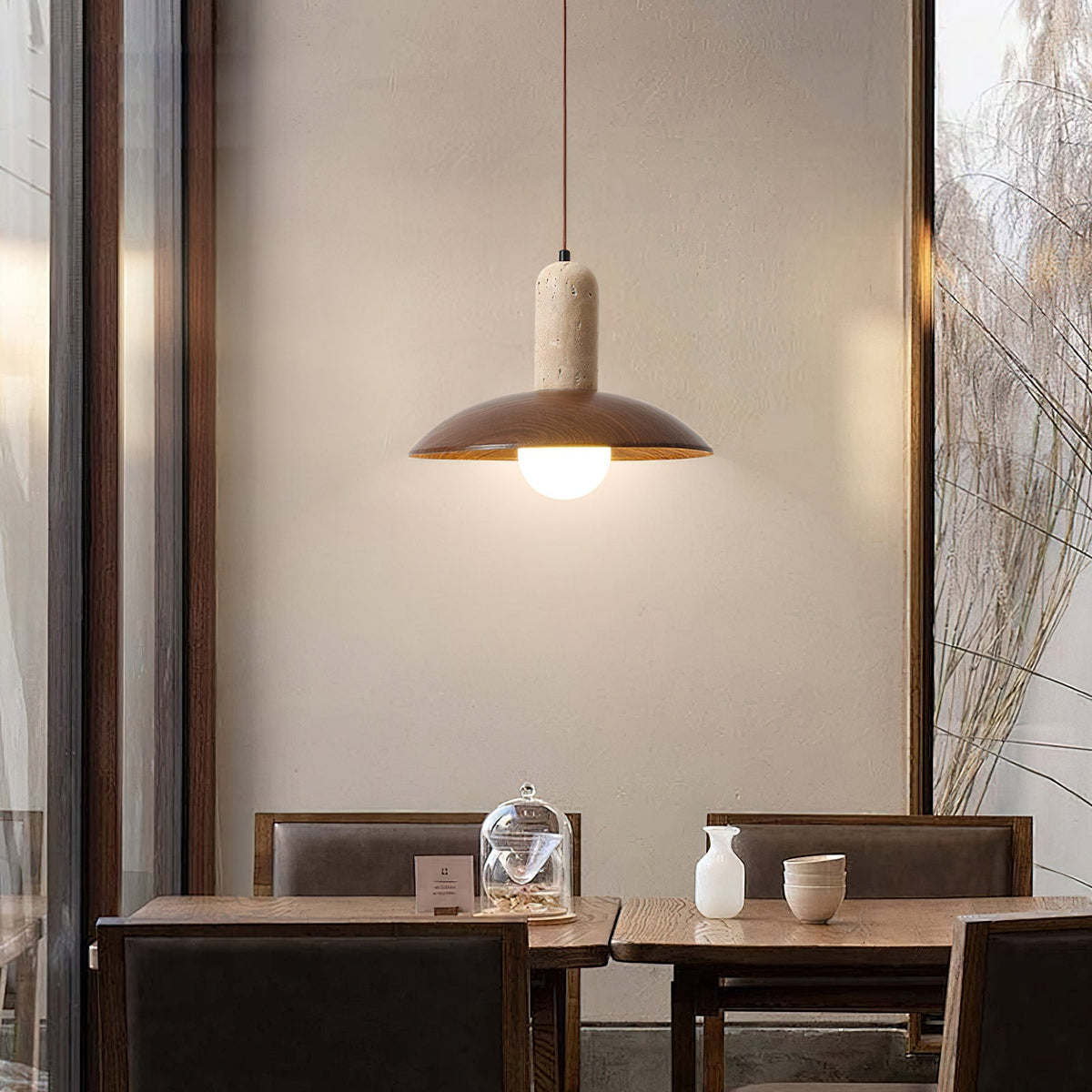 The Molly Pendant Lamp hanging in a modern dining area, providing warm light.