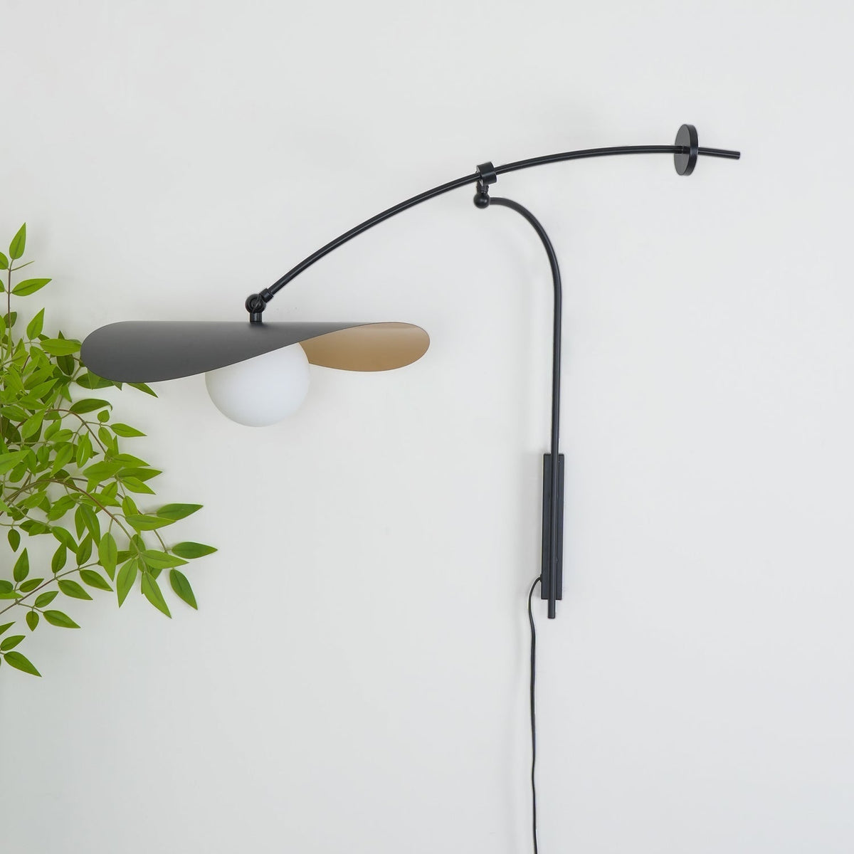 The large size Myrna Wall Lamp installed above a modern sofa.