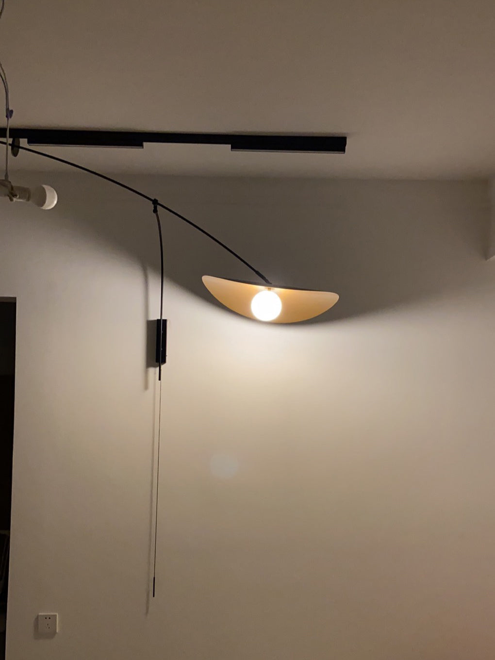 The large size Myrna Wall Lamp installed above a modern sofa.