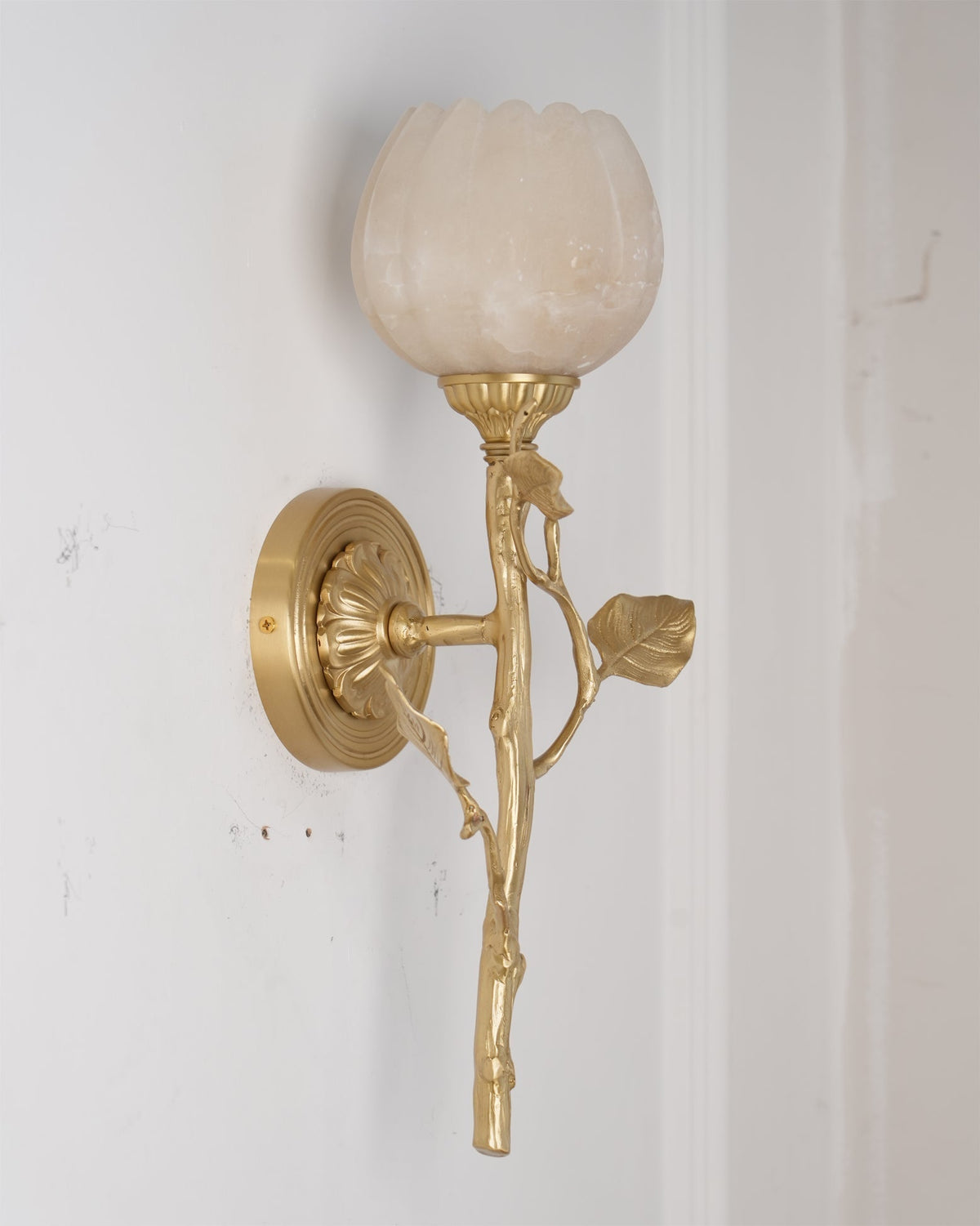 The unlit Natalia Wall Sconce against a dark wall, highlighting its form.