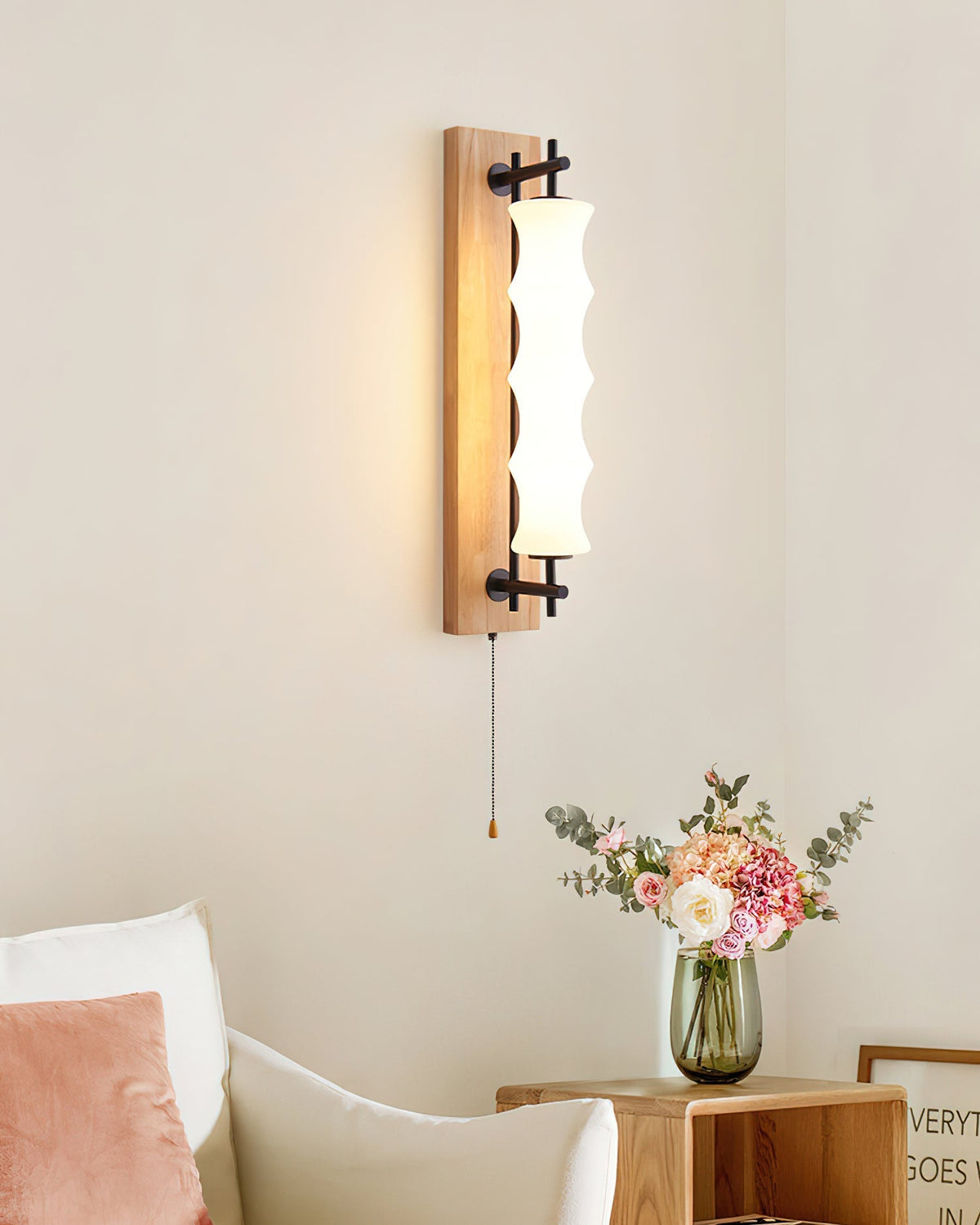 Nesta wall sconce in a walnut finish, highlighting the dark wood accent.