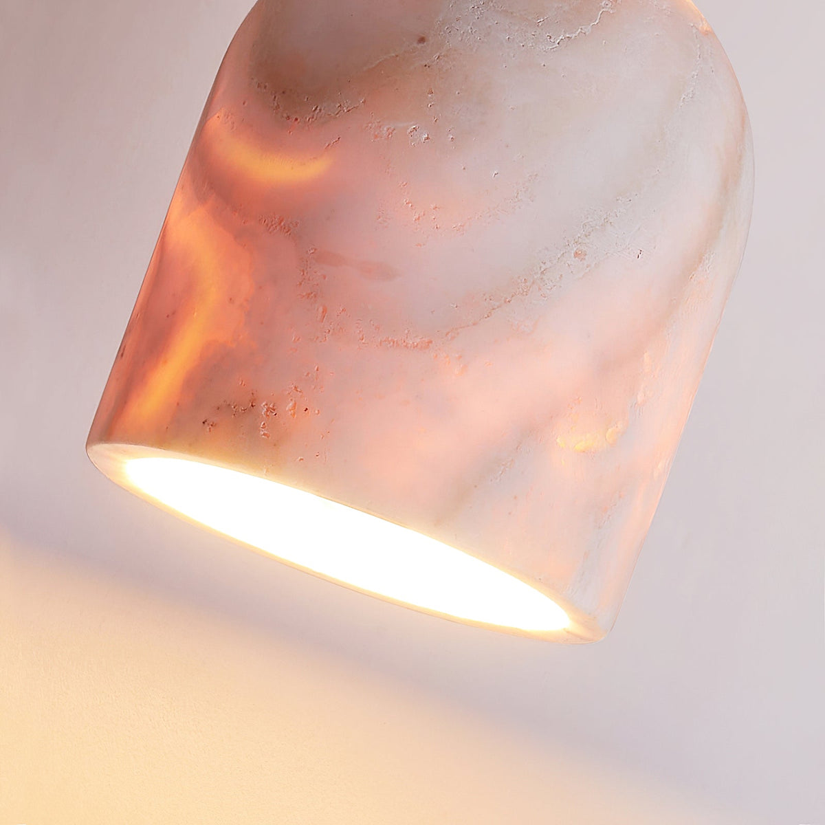 The lamp providing ambient light in a cozy bedroom setting.